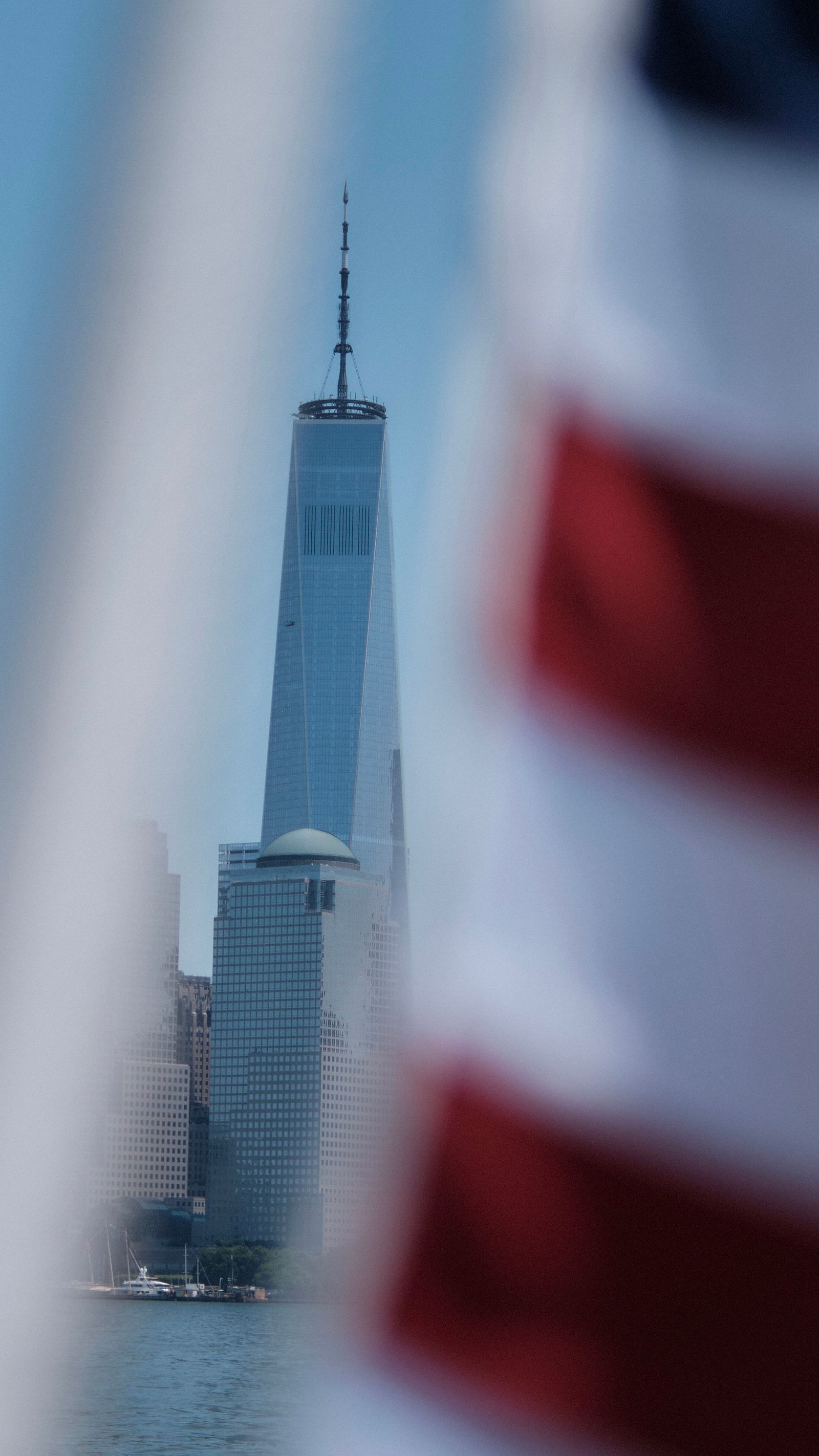 One World Trade Center framed by an American flag over New York Harbor